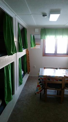 a room with a table and a green wall at Katterjokk Turiststation in Riksgränsen