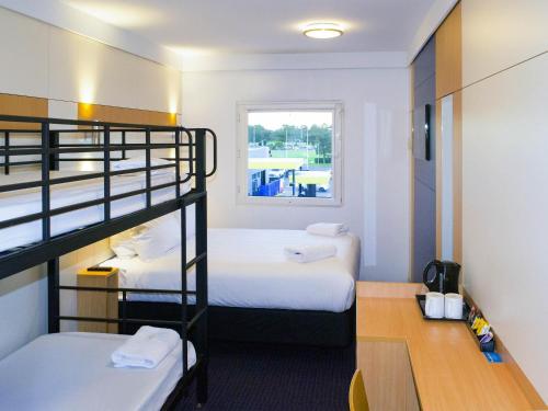 a room with two bunk beds and a desk at ibis Budget - Gosford in Gosford