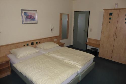 a bedroom with two twin beds and a closet at Hotel Ring Park in Buchen