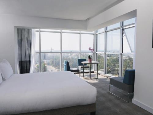 a bedroom with a bed and a table with chairs at Novotel Mohammedia in Mohammedia