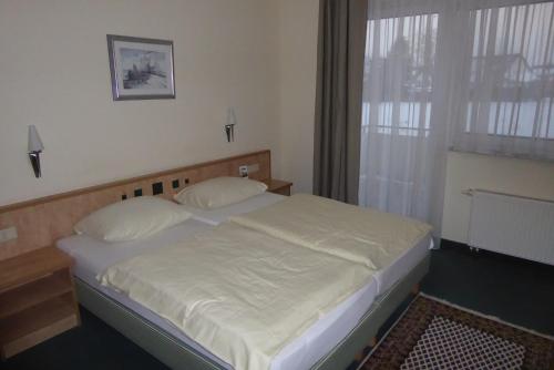 a bedroom with a bed and a window at Hotel Ring Park in Buchen