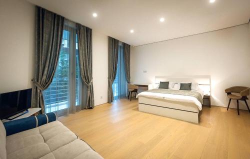 a large bedroom with a bed and a couch at Casa La Perla in Budva