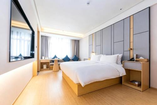 a bedroom with a large bed and a large window at JI Hotel Shanghai Stadium in Shanghai