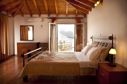 a bedroom with a bed in a room with a balcony at Filoxenia Hotel in Monemvasia