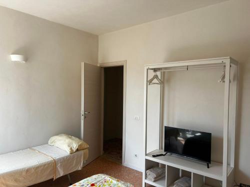 a bedroom with a bed and a flat screen tv at Correri 125 in Modica