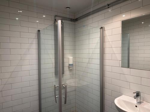 a bathroom with a glass shower and a sink at Måby Park Hotel Arlanda in Arlanda