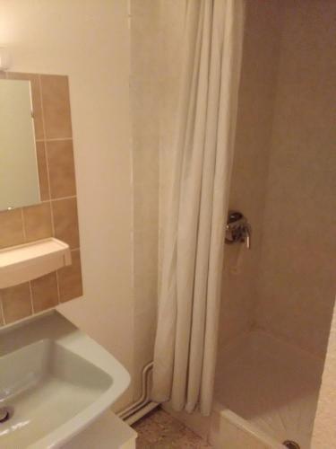 a bathroom with a shower curtain and a sink at Cap Verb Guillestre in Guillestre