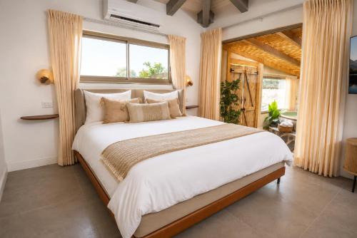 a bedroom with a large bed and a window at סוויטת דרים רויאל - סוויטה חלומית עם אמבט ספא מפנק ונוף מדהים in ‘Ein Ya‘aqov