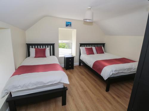 a bedroom with two beds with red and white sheets at Greenfield House in Aghavas