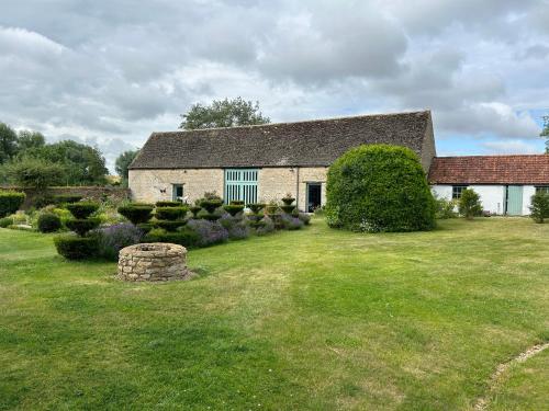 a large house with a yard with a grass field at Canutes Field bell tent in Nassington