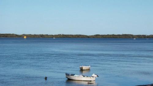 two boats sitting in the middle of the water at Brighton Le Sands Unit 6 in Golden Beach