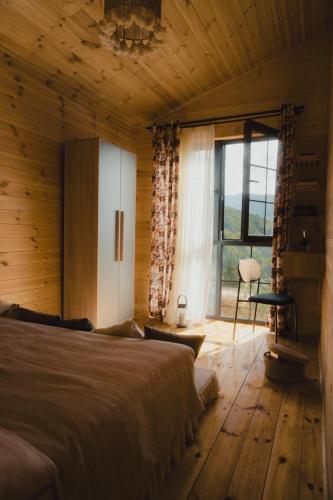 a bedroom with a bed and a large window at Haiku Cottages in Merisi