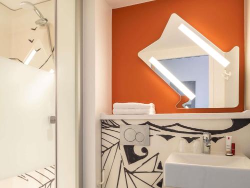 a bathroom with a sink and a mirror at ibis budget Gonesse Le Bourget in Gonesse