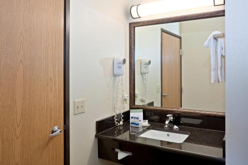 a bathroom with a sink and a mirror at AmericInn by Wyndham Douglas/Saugatuck in Saugatuck