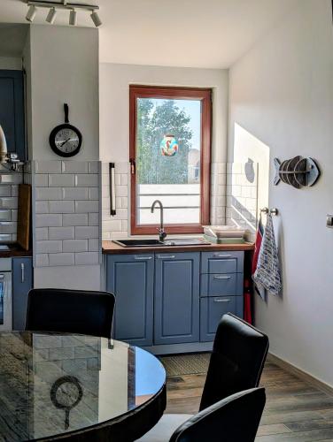 a kitchen with blue cabinets and a sink and a table at Sea View Holiday for Family and Friends Aheloy, near Sunny Beach-Почивка с изглед към морето за семейство и приятели Ахелой, близо до Слънчев бряг in Aheloy
