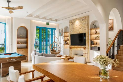 a living room with a table and a tv at S Villa Ha Long - City Center, Near Beach - 6BR Private Villa with Pool, Jacuzzi, Sauna, Karaoke in Ha Long