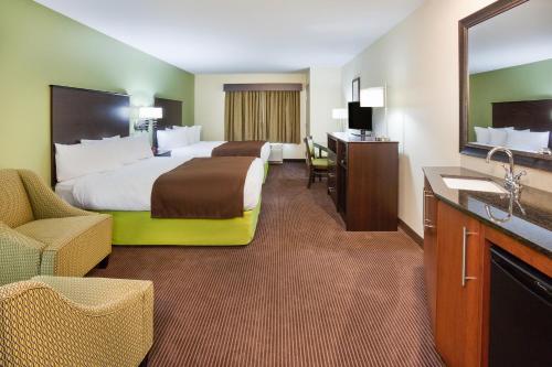 a hotel room with two beds and a sink at AmericInn by Wyndham Hartford SD in Hartford