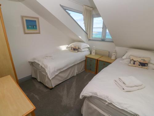 a attic room with two beds and a window at Ocean Gem in Carbis Bay