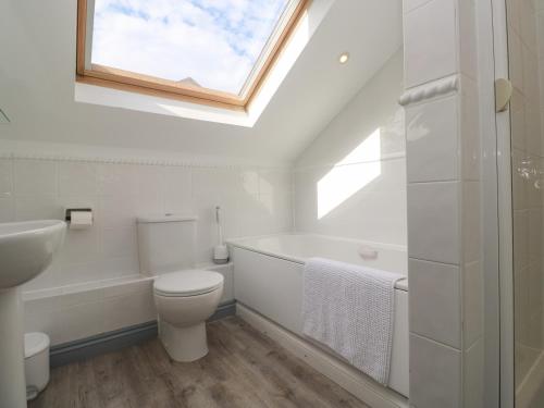 a bathroom with a toilet and a sink and a window at Ocean Gem in Carbis Bay