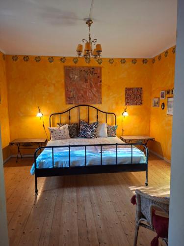 a bedroom with a bed in a room with yellow walls at Frida in Filipstad