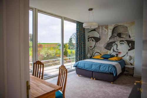 a bedroom with a bed and a large window at Villa Bianca in Dalhem
