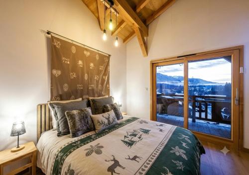 a bedroom with a bed with a large window at Chalet Arpitan - les Carroz - Grand Massif in Les Carroz d'Araches