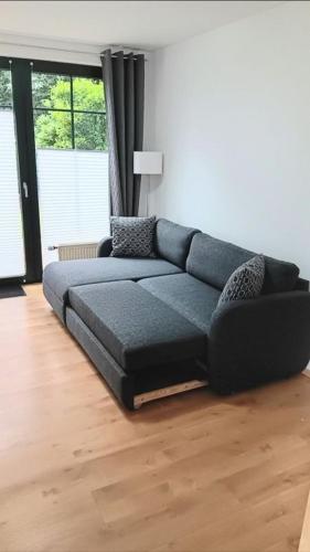 a living room with a blue couch in a room at Waldblick Nordhorn in Nordhorn