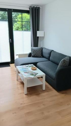 a living room with a blue couch and a coffee table at Waldblick Nordhorn in Nordhorn