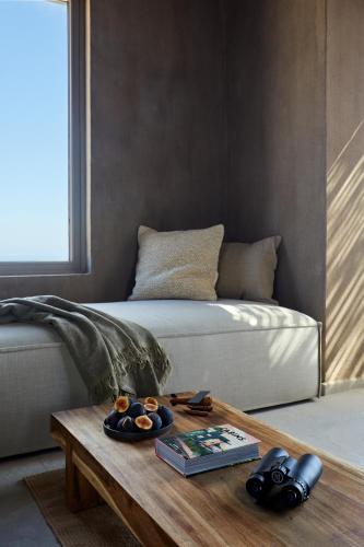 a living room with a bed and a coffee table at Santorini Sky, The Lodge in Pyrgos