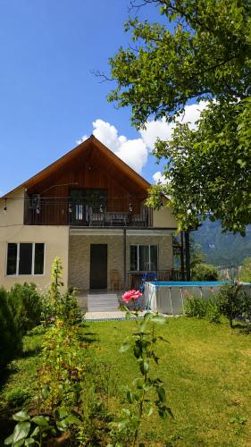 a house with a balcony on top of a yard at olya's garden in Tsʼageri