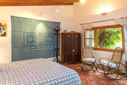 a bedroom with a bed and a cabinet and a window at Agroturisme s' Horta in Capdepera