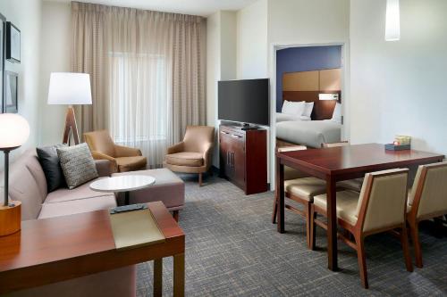 a hotel room with a desk and a living room at Residence Inn by Marriott Augusta in Augusta