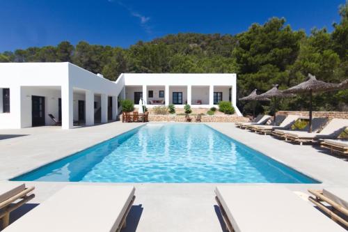 a villa with a swimming pool and lounge chairs at Villa Arenas in Sant Josep de sa Talaia