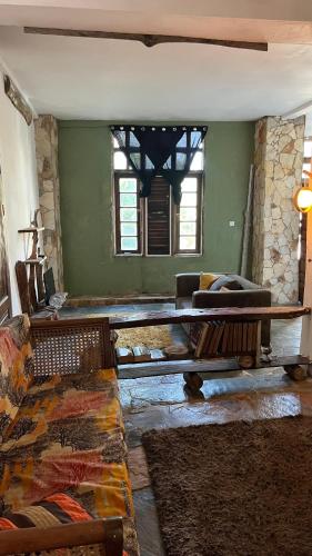 an empty living room with a table and a couch at Nature's Cradle Garden Lounge in Obosomasi