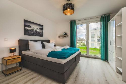 a bedroom with a bed and a large window at An der Haffküste Meerzeit in Zirchow