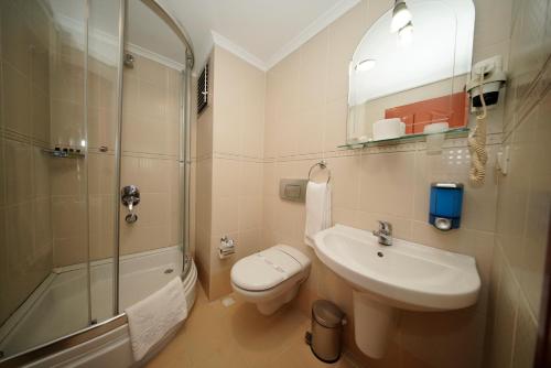 a bathroom with a sink and a toilet and a shower at Grand Hotel Seferoğlu in Istanbul