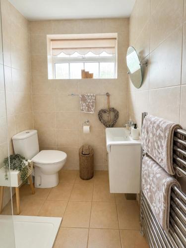 a bathroom with a toilet and a sink at Westfields Bungalow in Mirfield