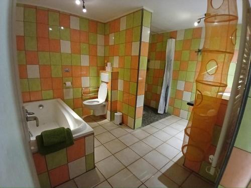 a bathroom with a tub and a toilet and a sink at Rimbes Casteljaloux - Gite 6 pers in Casteljaloux