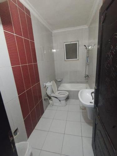 a bathroom with a toilet and a tub and a sink at شقة خلف السيفوي in Irbid