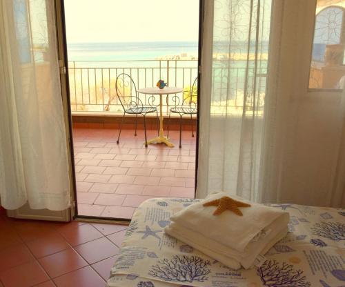 a bedroom with a bed and a view of the ocean at Palermo Mare Holidays in Sferracavallo