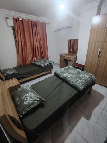 a room with two beds in a room with a window at شقة خلف السيفوي in Irbid