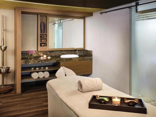 a bathroom with a sink and a bed in a room at Mövenpick Hotel Karachi in Karachi