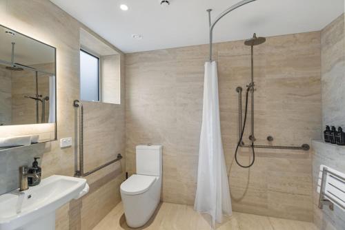 a bathroom with a toilet and a shower and a sink at Alp Studios Apartment 1 in Wanaka
