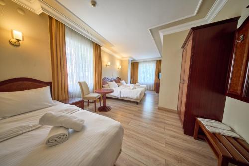 a hotel room with two beds and a living room at Grand Hotel Seferoğlu in Istanbul