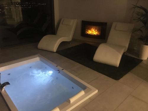 a living room with a hot tub and a fireplace at Petit Mirador in Torrelles de Llobregat