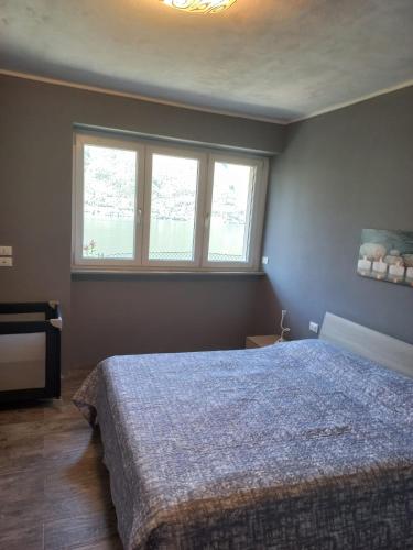 a bedroom with a bed and a large window at Giardino sul lago, La Vigna in Nesso