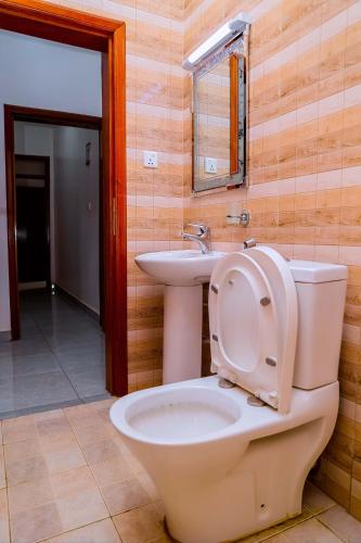 a bathroom with a toilet and a sink at Martin Aviator Hotel in Kigali
