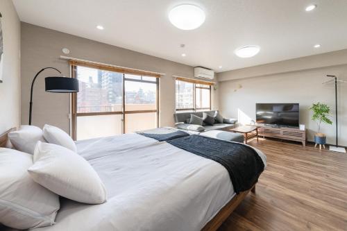 a large bedroom with a large bed and a living room at fleuve tenmonkan in Yamashitachō