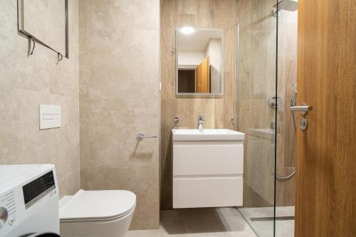 a bathroom with a toilet and a sink and a shower at APLEND Aparthotel Litvor in Štrba