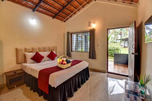 a bedroom with a bed with a basket of fruit on it at Orange Vista Resort Coorg in Kushālnagar